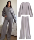 Woman wearing a gray outfit with a matching top and pants, with 'Trafza' branding.