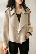Beige coat worn by a person against a neutral background