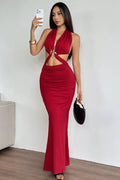 Woman in a red dress taking a selfie against a white wall.