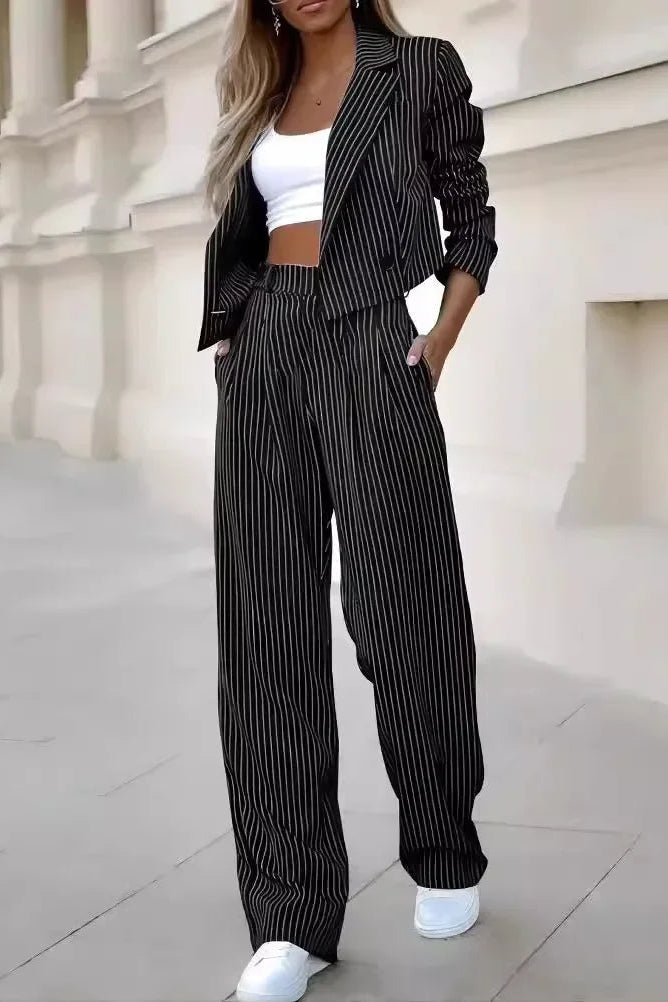 Woman wearing a black pinstripe suit with white sneakers in front of a classical building.