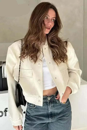 Woman wearing a beige jacket and blue jeans with a blurred background